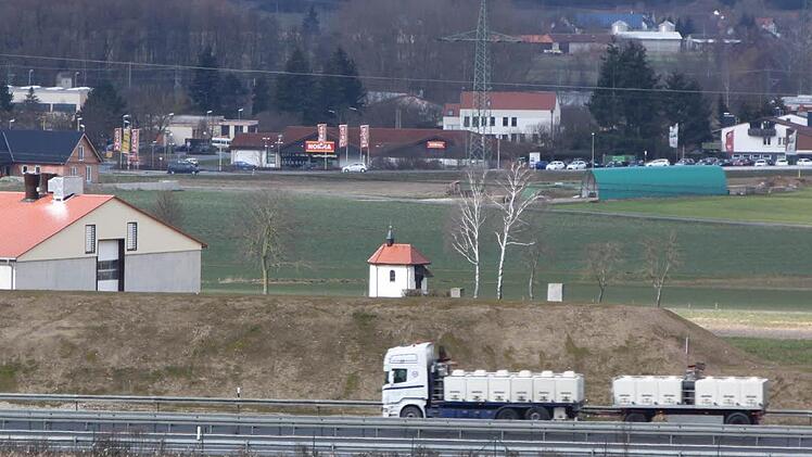 Etwa fünf Meter überragt die Oberkante des Lärmschutzwalls die Fahrbahn. Somit verschwinden Lastwagen dahinter. Die Bewohner Ebensfelds werden somit großenteils von dem Verkehrslärm verschont. Foto: Matthias Einwag