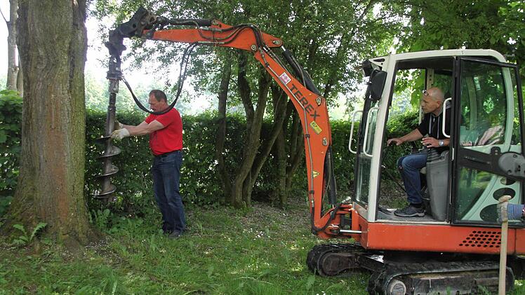 Mit schwerem Gerät werden die Pflanzlöcher für die Hecke gebohrt.
