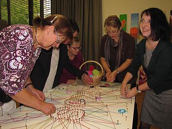 Da entsteht ein symbolisches Netzwerk rund um die Kontaktstelle Selbsthilfe. Sabine Feuerbach-Hein und Sabine Doerenkamp-Steiner (2. und 1. von rechts) legen mit Hand an. Foto: Martin Koch