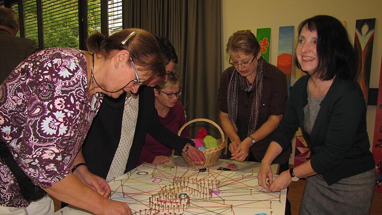 Da entsteht ein symbolisches Netzwerk rund um die Kontaktstelle Selbsthilfe. Sabine Feuerbach-Hein und Sabine Doerenkamp-Steiner (2. und 1. von rechts) legen mit Hand an. Foto: Martin Koch