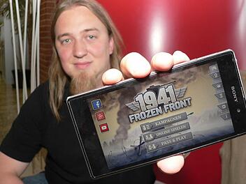 Gründer und Geschäftsführer Christopher Kassulke zeigt ein Smartphone mit einem von HandyGames entwickelten Spiel, das zuletzt besonders erfolgreich war. Foto: Matthias Litzlfelder