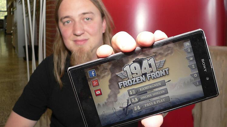 Gründer und Geschäftsführer Christopher Kassulke zeigt ein Smartphone mit einem von HandyGames entwickelten Spiel, das zuletzt besonders erfolgreich war. Foto: Matthias Litzlfelder
