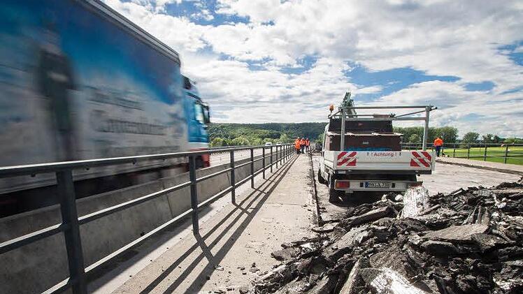 Berge von abgetragenem Asphalt reihen sich derzeit auf der Mainbrücke in Fahrtrichtung Schweinfurt. Die Kappen (mit den Geländern und Fahrbahnbegrenzungen), der Belag und die Übergangskonstruktionen der Brücke werden für vier Millionen Euro erneuert. Foto: Hendrik Steffens