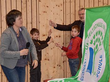 Die Umweltfahne wird im Beisein von Schulleiterin Claudia Klaas und Bürgermeister Waldemar Bug von zwei Schülern gehisst. Bisher fand diese Zeremonie im Schulhaus Lauter statt, diesmal durfte die Fahne in der Premicher Schulturnhalle wehen. Foto: Kathrin Kupka-Hahn
