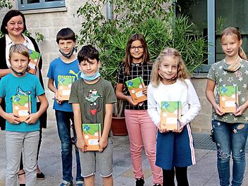 Stellvertretend für die übrigen Schüler überreichte Rektorin Jutta Aumüller an die Klassensprecher der vierten Jahrgangsstufe die besonderen "Möhrchen-Hausaufgabenhefte". Foto: Günther Geiling