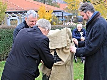 Bürgermeister Jürgen Hennemann, Kreisheimatpfleger Günter Lipp und der Ur-Ur-Ur-Enkel von Martin Baetz, Andreas Jost, enthüllen den Gedenkstein an der Georg-Nadler-Straße in Ebern. Foto: Helmut Will