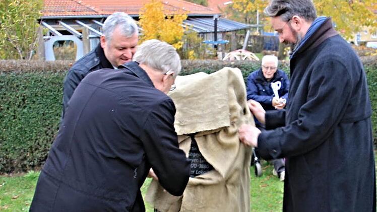 Bürgermeister Jürgen Hennemann, Kreisheimatpfleger Günter Lipp und der Ur-Ur-Ur-Enkel von Martin Baetz, Andreas Jost, enthüllen den Gedenkstein an der Georg-Nadler-Straße in Ebern. Foto: Helmut Will