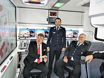 Kreisbrandmeister Marcel Hocquel (stehend) gibt als Leiter der Unterstützungsgruppe des Örtlichen Einsatzleiters (UG-ÖEL) Anschauungsunterricht im Innenraum des Einsatzleitwagens für (von links) Landrat Klaus Peter Söllner, Kreisbrandrat Stefan Härtlein und THW-Zugführer Andreas Hock.