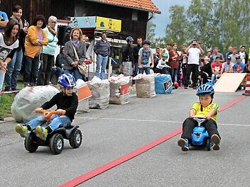 Ein Hauch von Formel 1 wehte am Kirchweihsamstag in der Gemeinde Schneckenlohe, wo das 5. Bobby-Car Rennen stattfand, bei dem es spannende Duelle gab. Mit teils hohen Geschwindigkeiten ging es in der Waldstraße bergab. Unsere Aufnahme zeigt den Endlauf der jüngsten Altersklasse fünf bis sieben Jahre, den Tim Altrichter (rechts) gegen Luis Geßlein gewann. Foto: Herbert Fischer