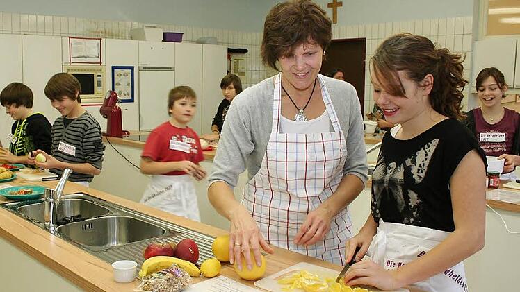 Doris Ehrenschwender (Zweite von rechts) und Lola Riehlein (rechts) bei der Herstellung von Obstsalat  Foto: Evi Seeger