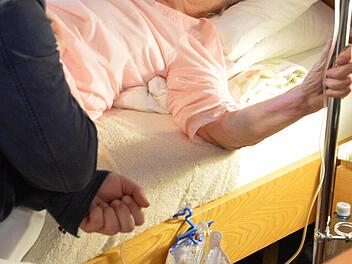 Die Patientin kann zuhause in ihrem eigenen Bett versorgt werden und im Gespräch mit dem Palliativmediziner über ihr Befinden sprechen. Foto: Ronald Rinklef
