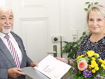Hartmuth Grosch überreicht an Claudia Leipold eine Urkunde der Steuerberaterkammer Nürnberg und einen Blumenstrauß. Er dankt ihr für ihre 40-jährige Mitarbeit.