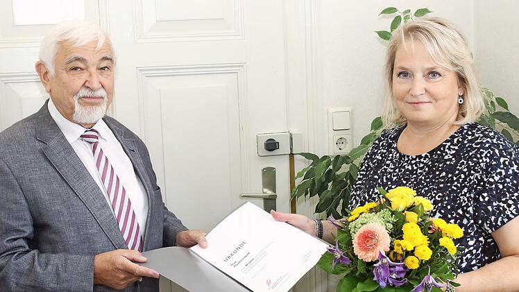 Hartmuth Grosch überreicht an Claudia Leipold eine Urkunde der Steuerberaterkammer Nürnberg und einen Blumenstrauß. Er dankt ihr für ihre 40-jährige Mitarbeit.