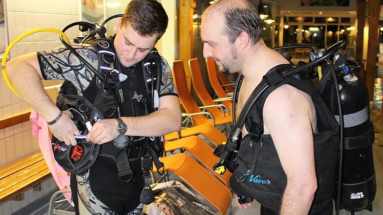Tauchlehrer Christian Kötzner (links) und Tauchschüler Marc Handel checken gegenseitig die Ausrüstung, bevor sie ins Wasser gehen. Foto: Julia Raab