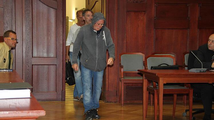 An den Füßen gefesselt, wird der Brandstifter von Oberzettlitz in den Gerichtssaal geführt. Der 65-jährige Angeklagte aus Bad Kissingen hat sich bei den Opfern entschuldigt. Foto: Stephan Tiroch