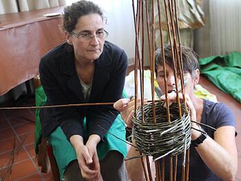 Flechtwerkgestalterin Gitti Klitzner zeigt einer Kursteilnehmerin, wie es geht. Foto: Gerda Völk