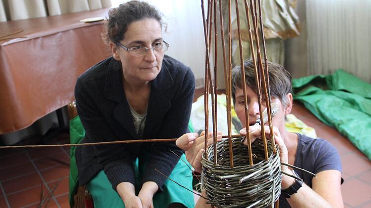 Flechtwerkgestalterin Gitti Klitzner zeigt einer Kursteilnehmerin, wie es geht. Foto: Gerda Völk