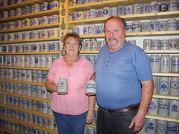 Maria und Hans Fehn vor einer großen Wand mit Bierkrügen im  Keller ihres HausesHeike Schülein