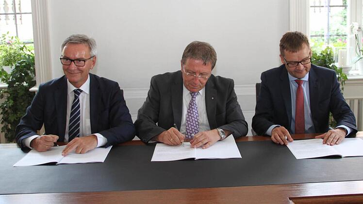 Stadtwerke-Leiter Stephan Pröschold, OB Henry Schramm und Reimund Gotzel von der Bayernwerk AG (von links) unterzeichnen den Vertrag.
