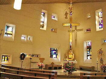 Durch die farbigen Fenster und das Schattenspiel von Kreuz und Marienfigur an der Wand entfaltet der Innenraum der Kirche St. Johannes der Täufer in Weisbrunn eine ganz besondere Atmosphäre. In Weisbrunn wird am Sonntag das 50. Kirchenjubiläum gefeiert.  Foto: Sabine Weinbeer