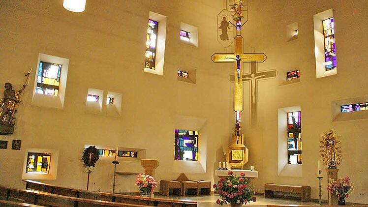 Durch die farbigen Fenster und das Schattenspiel von Kreuz und Marienfigur an der Wand entfaltet der Innenraum der Kirche St. Johannes der Täufer in Weisbrunn eine ganz besondere Atmosphäre. In Weisbrunn wird am Sonntag das 50. Kirchenjubiläum gefeiert.  Foto: Sabine Weinbeer