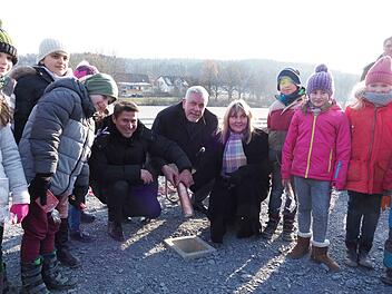 Was lange w&auml;hrt, wird endlich gut! Oberb&uuml;rgermeister Norbert Tessmer legte am Donnerstag eine Metallh&uuml;lse mit Zeitdokumenten und M&uuml;nzen in den Grundstein des B&uuml;rger- und Stadtteilhauses am W&uuml;stenahorner Wolfgangsee. Unterst&uuml;tzt wurde er dabei vom Gesch&auml;ftsf&uuml;hrer der Wohnbau Coburg, Christian Meyer (links), und von Bau-B&uuml;rgermeisterin   Birgit Weber. Flankiert wurden sie von den Kindern aus der Melchior-Franck-Schule sowie dem Kindergarten Pfiffikus. Foto: Christoph Winter