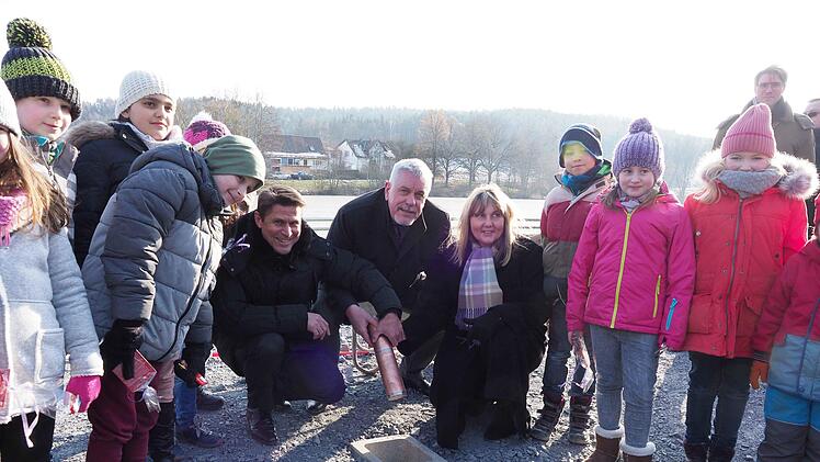 Was lange währt, wird endlich gut! Oberbürgermeister Norbert Tessmer legte am Donnerstag eine Metallhülse mit Zeitdokumenten und Münzen in den Grundstein des Bürger- und Stadtteilhauses am Wüstenahorner Wolfgangsee. Unterstützt wurde er dabei vom Geschäftsführer der Wohnbau Coburg, Christian Meyer (links), und von Bau-Bürgermeisterin   Birgit Weber. Flankiert wurden sie von den Kindern aus der Melchior-Franck-Schule sowie dem Kindergarten Pfiffikus. Foto: Christoph Winter