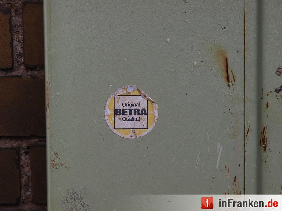 Detailaufnahme eines Aufklebers auf der Metallkiste