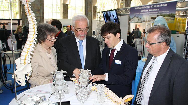 Oberarzt Marco Amann (rechts) vom Orthopädischen Bezirkskrankenhaus Schloss Werneck erläutert Eva Maria Roer, Vorsitzende des Fördervereins Gesundheitszentrum Bad Kissingen, Regierungspräsident Paul Beinhofer und den stellvertretenden Landrat Emil Müller an Modellen neue Ansätze in der operativen Schmerztherapie. Foto: Ralf Ruppert