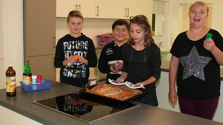 Ofenfrische Pizza aus der neuen Schulküche servieren Tommy, Joaquim, Ria und Louisa (von links) als Pausensnack .