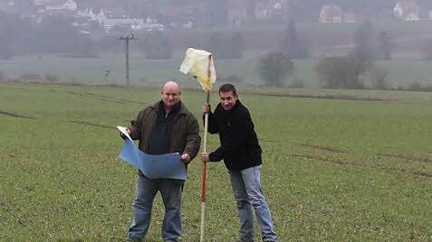 Klaus Schebler (links) und  Fabian Nöth markieren den Standort eines Windrades. Im Hintergrund ist Burghausen zu sehen. Fotos: Björn Hein