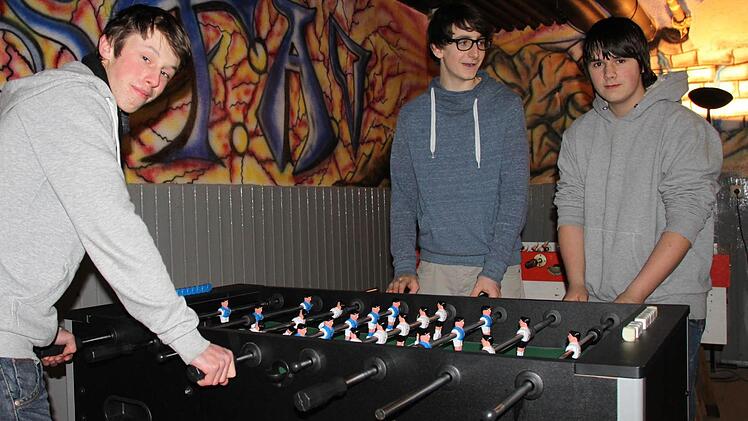 Marcel (von links), Maximilian und Andreas probieren den Kicker aus.