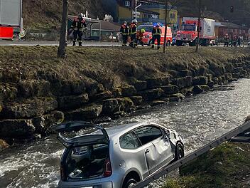 Der verunglückte Wagen in der Sinn.  Der Fahrer konnte sich nicht selbstständig aus dem Auto befreien.