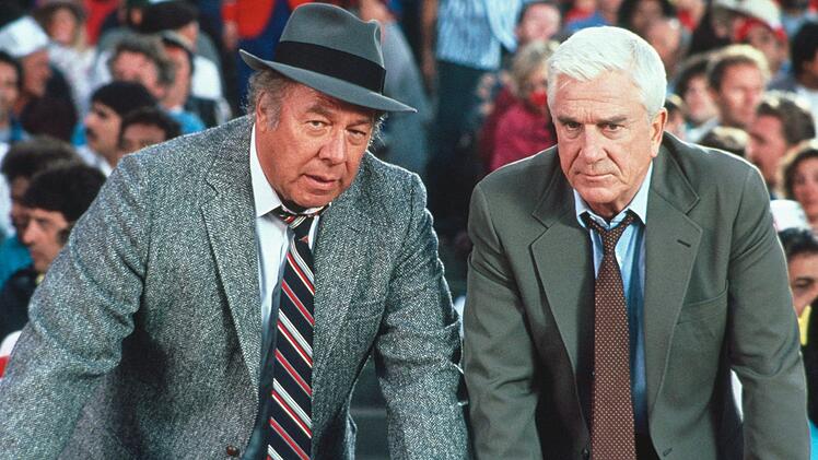 Ed Hocken (George Kennedy, links) und Frank Drebin (Leslie Nielsen) suchen im weiten Rund des Baseballstadions nach einem Attent&auml;ter.