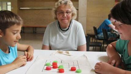 Eine witzige Spielidee: Alexander Ultsch (9) und Carina Schüßler (10) haben auf Stofftaschen der Abfallwirtschaft Mühlebretter gezeichnet - und alte Schraubverschlüsse von Flaschen als Mühlesteine gesammelt. Lehrerin Nelli Döppmann ist begeistert.