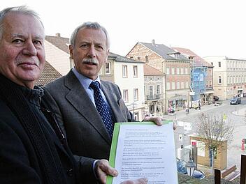 Hans-Günther Schlüter überreicht Bürgermeister Ernst Stross die Unterschriften der Anwohner und Geschäftsleute. Foto: Arkadius Guzy