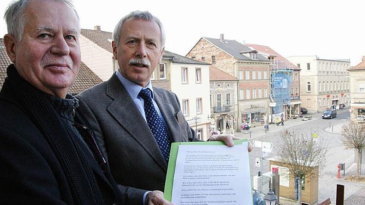 Hans-Günther Schlüter überreicht Bürgermeister Ernst Stross die Unterschriften der Anwohner und Geschäftsleute. Foto: Arkadius Guzy