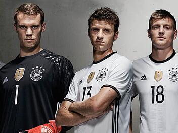 Das neue Trikot der deutschen Fußball-Nationalmannschaft für die EM 2016 getragen von den Fußballnationalspielern Bastian Schweinsteiger, Torwart Manuel Neuer, Thomas Müller und Toni Kroos. Foto: Adidas/dpa