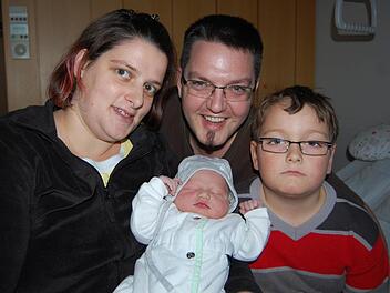 Seit dem Neujahrsmorgen sind sie zu viert! Die bislang dreiköpfige Familie Faber aus dem Seßlacher Stadtteil Unterelldorf freut sich über die Geburt von Jonas. Im Bild der kleine Wonneproppen mit seinen Eltern Nadine und Jens sowie dem großen Bruder Justin. Foto: Oliver Schmidt