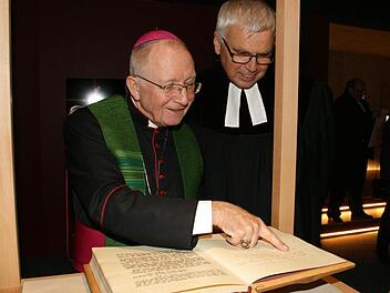 Eine besondere Bibel steuerte Weihbischof Ulrich Boom (links) für die Dauerausstellung "Auf der Spur von Jesus" bei. Sie ist von ihm handgeschrieben. Seinem "Amtsbruder" Landesbischof i.R. Johannes Friedrich erläuterte er, welche Bibelabschnitte ihm dabei besonders wichtig waren.  Foto: Sabine Weinbeer