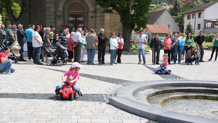 Mit dem Bobbycar um den Brunnen herum.