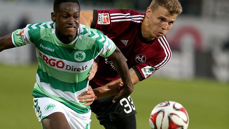 Der Fürther Abdul Rahman Baba (l) kämpft mit dem Nürnberger Tobias Pachonik um den Ball. Foto: Daniel Karmann/dpa