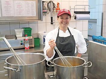 Laura Bauer, Azubi zur Köchin im letzten Lehrjahr, kocht Orangensaft mit Gewürzen für marinierte Rumfrüchte. Foto: Monika Schütz