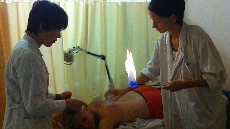 In TCM-Kliniken in Peking lernte Hebamme Claudia Kaiser (rechts), wie alte Heilmethoden - etwa Schröpfen - in China angewandt werden.