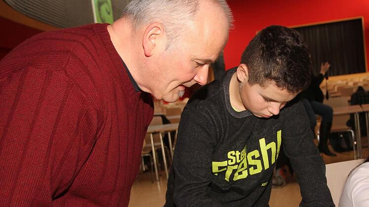 Spieletrainer Michael Keim mit einem Schüler bei Herausfinden von geometrischen Figuren und Flächen. Foto: Günther Geiling