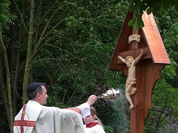 Als ein Wegzeichen und einen Wegweiser von der Kirche zum Friedhof bezeichnete Pfarrer Peter Göttke bei der Weihe das neue hölzerne Kreuz, das Robert Kober geschnitzt und seiner Gemeinde zum Doppeljubiläum gestiftet hat.
