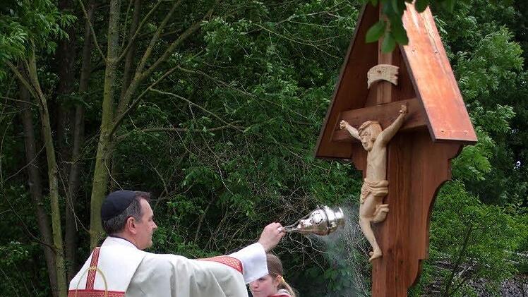 Als ein Wegzeichen und einen Wegweiser von der Kirche zum Friedhof bezeichnete Pfarrer Peter Göttke bei der Weihe das neue hölzerne Kreuz, das Robert Kober geschnitzt und seiner Gemeinde zum Doppeljubiläum gestiftet hat.