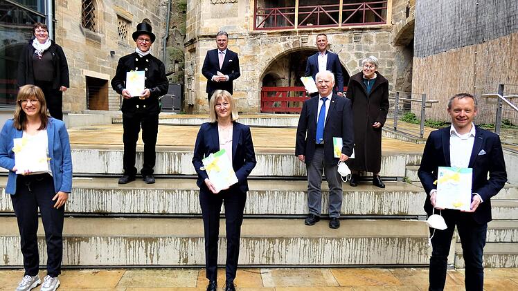 Die Übergabe: (vorne, von links) Katharina Hasemann (Ireks), Anja Wimmer (Wimmer GmbH), Christian Alexy (Wagner Treppenbau),  (in  der Mitte, von  links) Klimamanagerin Ingrid Flieger, Ralf Gröbner (Kaminkehrermeister), Hans Schwender mit Ehefrau  Ursula, (oben,  von links) Landrat Klaus Peter Söllner und Marcus Raabe (Wiegel Gebäudetechnik).