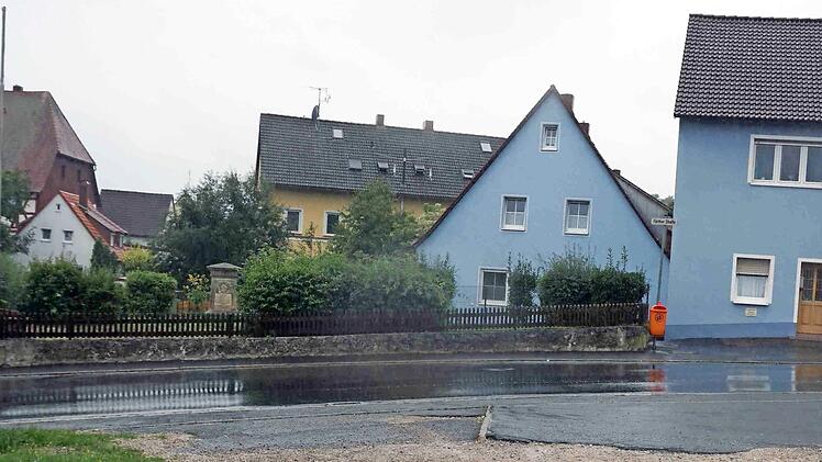 Die Brache im Vordergrund und die gegenüberliegende Fläche mit Kriegerdenkmal und Grabstein auf dem ehemaligen Kloster-Friedhof sollen zur neuen Ortsmitte von Münchaurach umgestaltet werden. Foto: Sänger