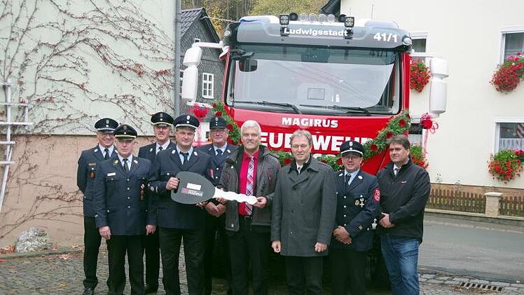 Symbolische Schlüsselübergabe von Bürgermeister Timo Ehrhardt (4. v. re.) an Kommandant Jörg Söllner (4. v. li.). Mit im Bild Landrat Klaus Löffler (3. v. re.), Magirus-Vertriebsbeauftragter Mario Tauber (rechts) sowie Vertreter der Wehr und der Kreisbrandinspektion mit KBR Joachim Ranzenberger (2. v. li.). Heike Schülein